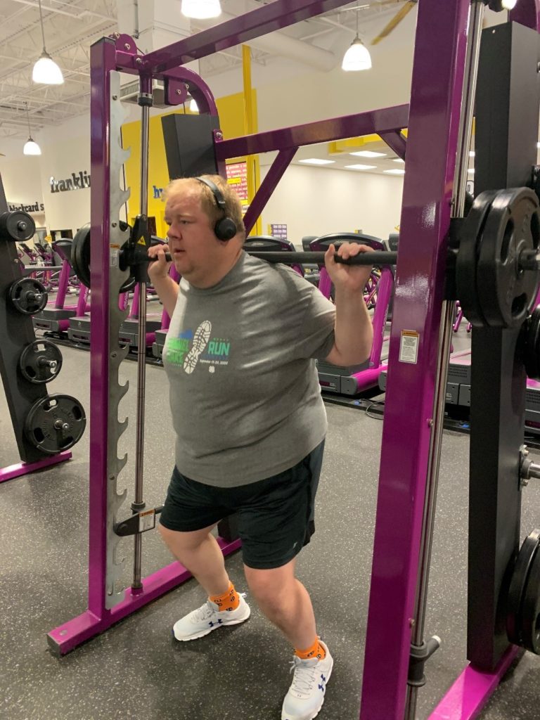 Mr. Crowe in a gym lifting heavy weights.