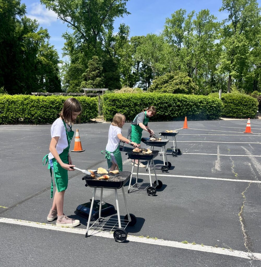 three 4-H members each a their own grill flipping food.