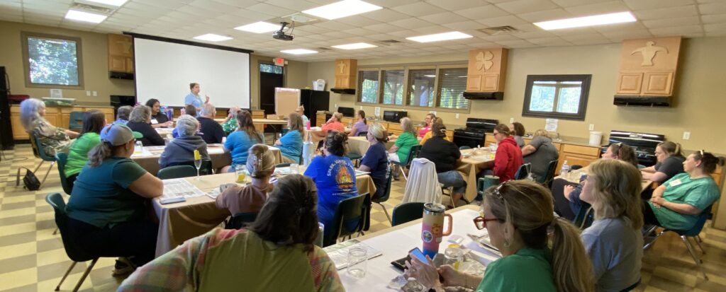 Group of adults sitting in a room listening to a presenter.